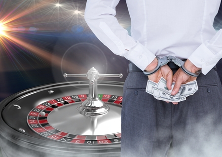 Digital composite of Man in hand cuffs with money and 3d roulette machineの写真素材