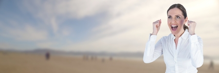 Digital composite of Business woman celebrating on blurry beachの写真素材