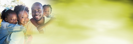 Digital composite of Family piggy backs with blurry green copy space transitionの写真素材