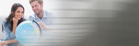 Digital composite of Couple looking at globe and blurry grey transitionの写真素材