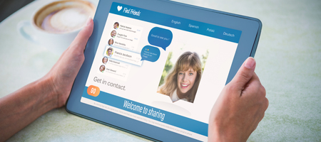 3D interface of chat application against person holding tablet computer at table in cafe