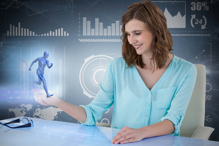 Smiling businesswoman sitting at desk and using digital 3D screen against purple vignetteの写真素材