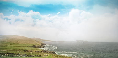 Scenic view of landscape by ocean against skyの写真素材