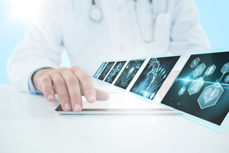 Doctor using digital 3D tablet against white background against blue vignette backgroundの写真素材