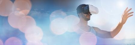 Digital composite of Man Wearing VR Headset with sparkling lights bokeh transition