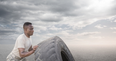 Digital composite of Soldier man pushing a wheel against desert backgroundの写真素材