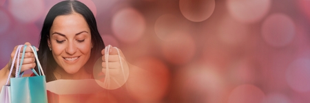 Digital composite of Woman shopping with bags and sparkling lights bokeh transitionの写真素材