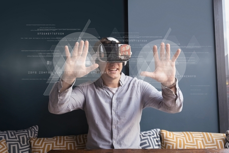 Digital composite of Happy man in VR headset touching interfaces with flares