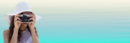 Digital composite of Millennial woman in summer hat with camera against light blue backgroundの写真素材