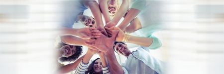 Digital composite of Low angle of creative team and putting hands together and blurry white framingの写真素材