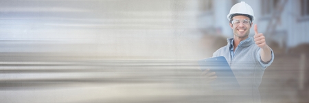 Digital composite of Construction Worker with thumbs up in front of construction site with...