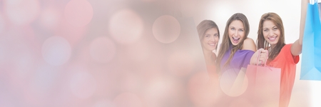 Digital composite of Women shopping with bags and sparkling lights transitionの写真素材