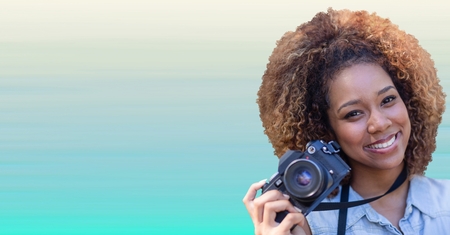 Digital composite of Close up of millennial woman with camera against light blue backgroundの写真素材