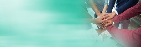 Digital composite of Creative team putting hands together and blurry teal transition