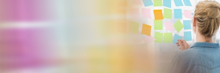 Digital composite of Back of woman looking at sticky notes and blurry sticky note transitionの写真素材