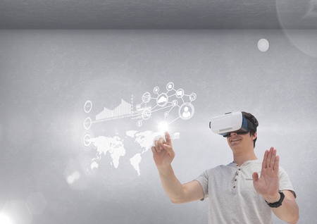 Digital composite of Happy man in VR headset touching interface against grey background with flares