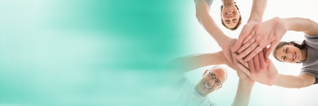 Digital composite of Low angle of volunteer team putting hands together and blurry teal transition