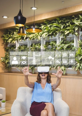 Digital composite of Happy woman in VR headset pointing at interface