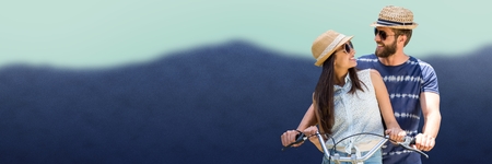 Digital composite of Couple on bicycle against blurry mountainの写真素材