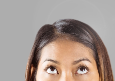 Digital composite of Portrait of woman's eyes with grey backgroundの写真素材