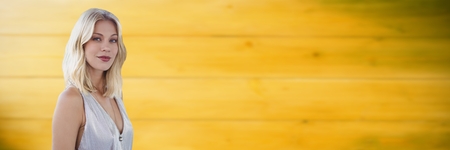 Digital composite of Woman in white dress against blurry yellow wood panelの写真素材
