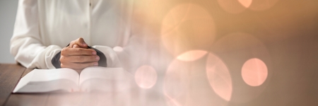 Digital composite of Hands on bible and peach bokeh transitionの写真素材