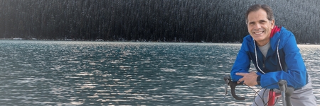 Digital composite of Middle aged man on bicycle against river and forestの写真素材