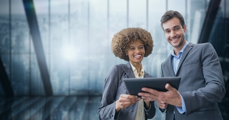 Digital composite of Happy business people holding a tablet