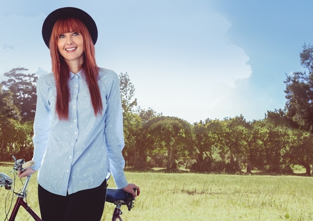 Digital composite of Millennial woman with bicycle against fieldの写真素材