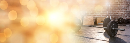 Digital composite of Barbells in Gym with sparkling  transitionの写真素材