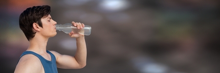 Digital composite of Man in training gear drinking water against blurry brown backgroundの写真素材