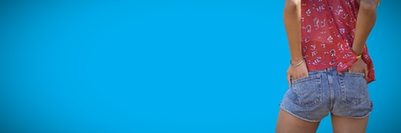 Digital composite of Back of millennial woman lower body against blue backgroundの写真素材