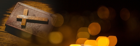 Digital composite of Cross on bible and black yellow bokeh transitionの写真素材