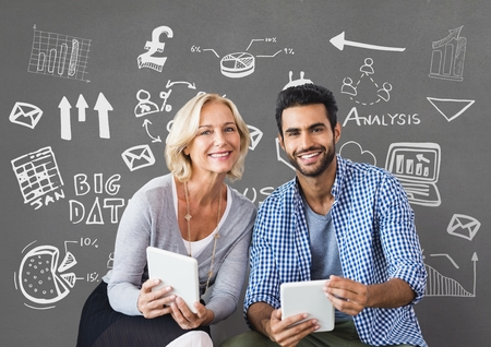 Digital composite of Happy business people holding tablets against grey background with graphicsの写真素材