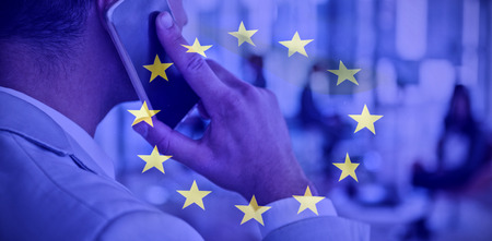 European flag against businessman talking on mobile phoneの写真素材