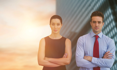 Business colleagues posing with crossed arms  against view of office buildingの写真素材