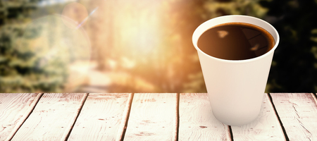 Coffee cup over white background against road through forestの写真素材