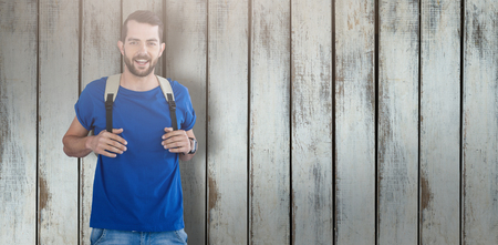 Portrait of man with backpack against white background against wood backgroundの写真素材