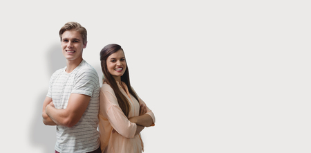 Young smiling people are posing with crossed arms  against grey backgroundの写真素材