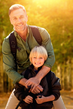 Father with his son  against walkway along lined trees in the parkの写真素材