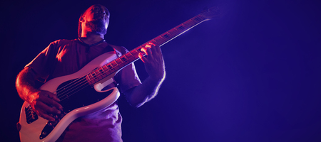 Low angle view of male guitarist performing at nightclubの写真素材