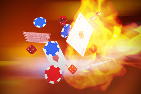 3D image of playing cards with dice and casino tokens against defocused image of illuminated lighting equipmentの写真素材