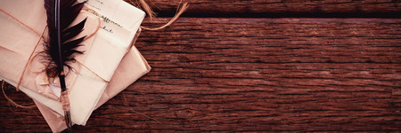 Quill feather with nostalgic letters on wooden tableの写真素材