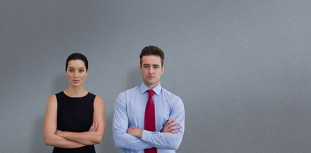 Business colleagues posing with crossed arms  against grey backgroundの写真素材