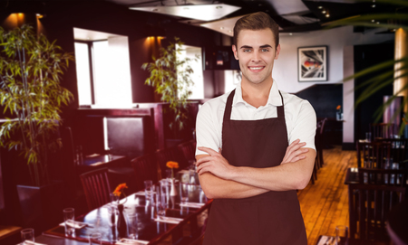 Portrait of young man with arms crossed against restaurant interiorの写真素材