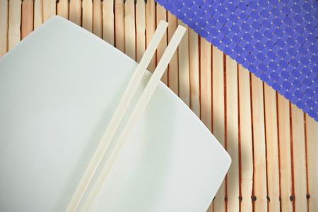 Close up of chopsticks with tissu against close up of sushi matの写真素材