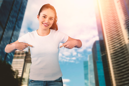 Portrait of smiling brunette woman in front of white background against cityの写真素材