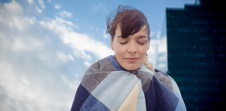 Portrait of brunette women wearing scarf against cloudscape in sky by glass building