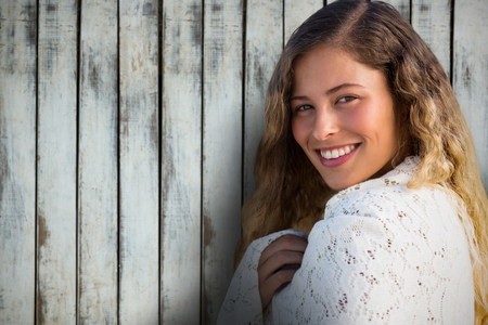 Portrait of beautiful brunette woemn against wood backgroundの写真素材