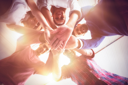 Business people forming hands stack at officeの写真素材